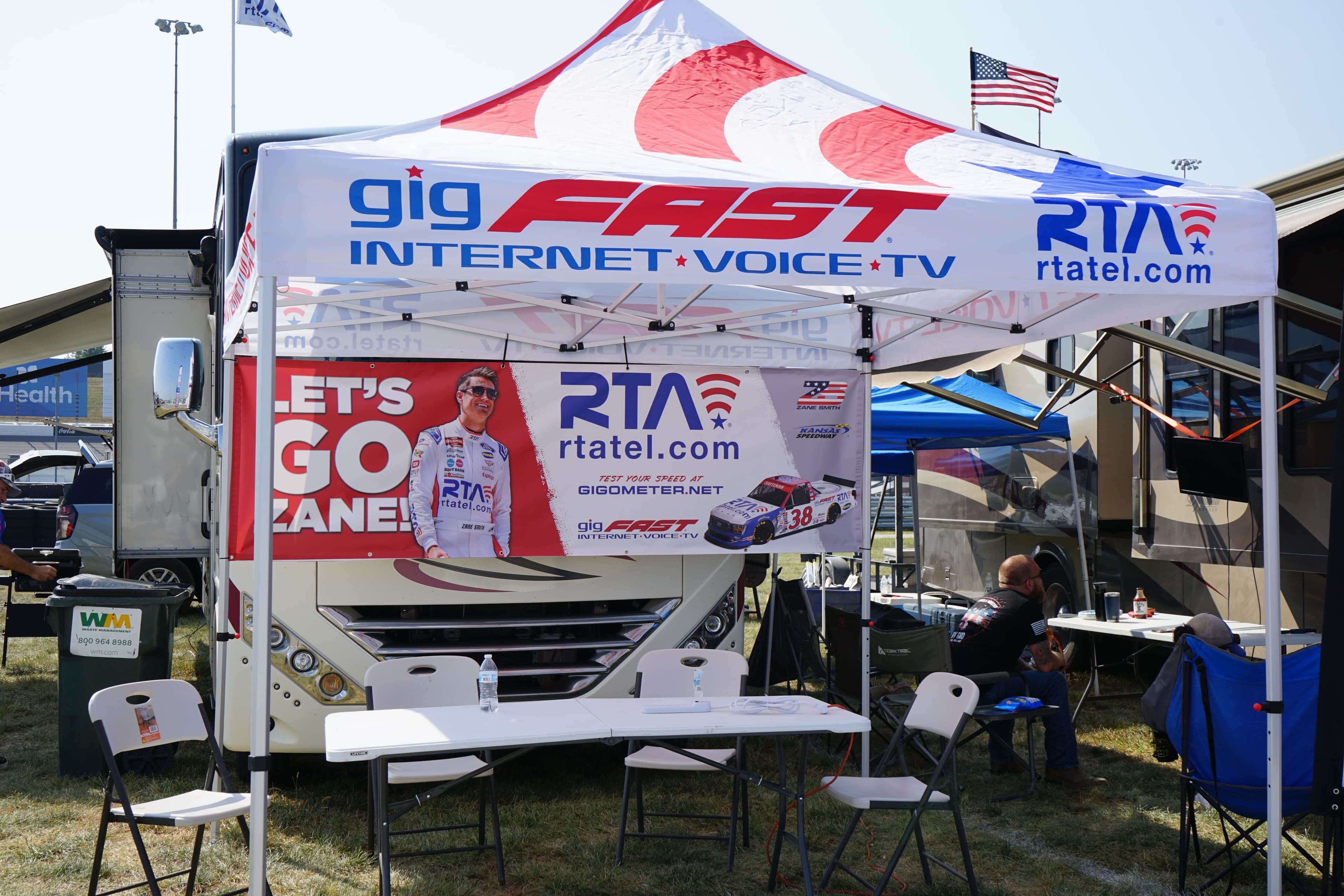 Branded event tent with gigFAST Internet and RTA logos, LET'S GO ZANE banner in background